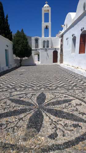 Megalo Chorio’daki kilisenin çakıl taşlarından mozaiklerle bezeli avlusu 